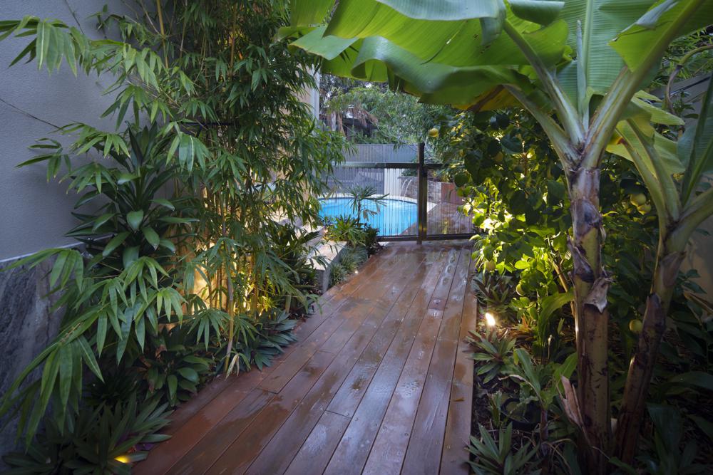timber path through lush garden provides access to the pool of the boutique home in floreat near perth.