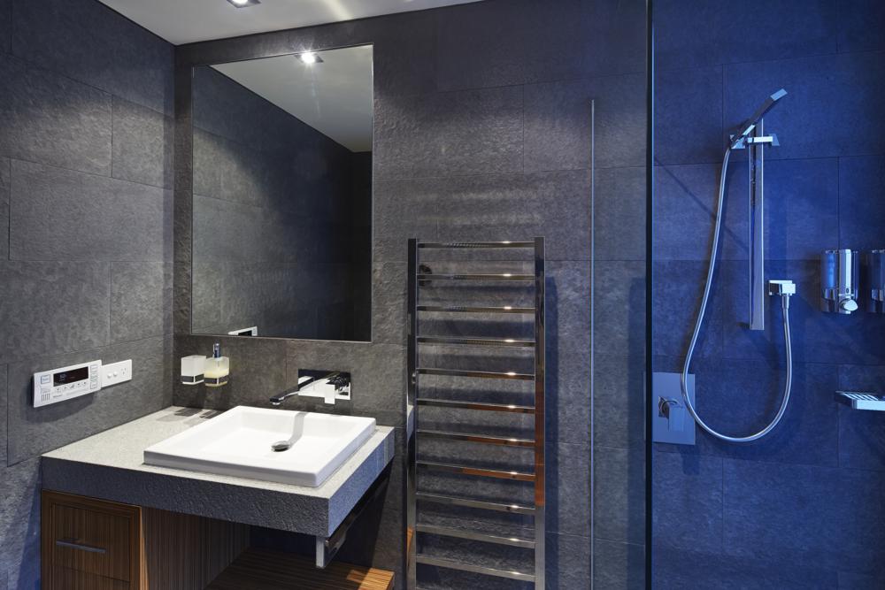 stone tile walls, glass shower screen and modern square sink in second bathroom.