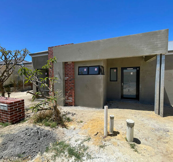 Front-facing NDIS villa 'a' at lockup stage. Shows brick and render not yet painted.